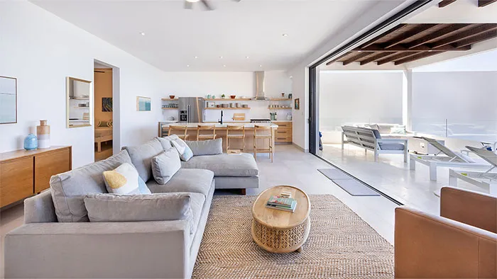 The-Cove-At-Cerritos-Residence-602 - Open-concept living area in Residence 602, featuring a comfortable sectional sofa, modern coastal décor, and seamless access to the ocean-view terrace.
